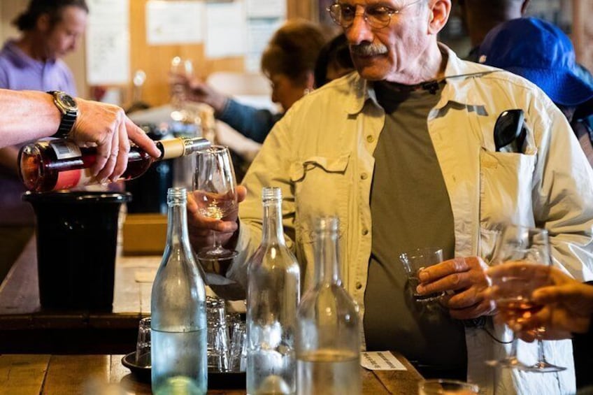 Staff top up a moustachioed man's glass during a wine tasting at Yering Farm winery in the Yarra Valley.