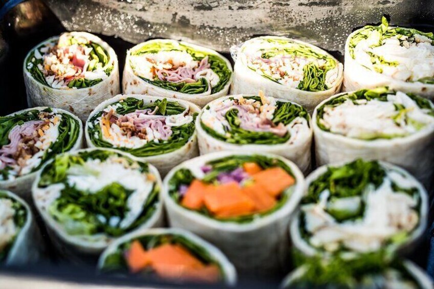 Fresh deli lunch includes assorted wraps - Chicken Caesar, Ham BLT, or Falafel/Veggie (GF wrap available upon request).