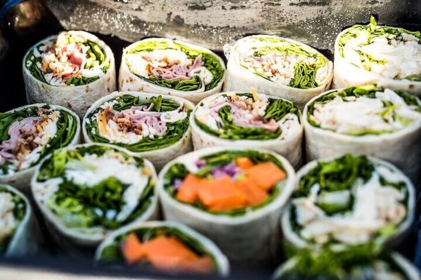 Fresh deli lunch includes assorted wraps - Chicken Caesar, Ham BLT, or Falafel/Veggie (GF wrap available upon request).