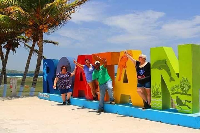 Our cruise guests enjoying the Roatan color sign 