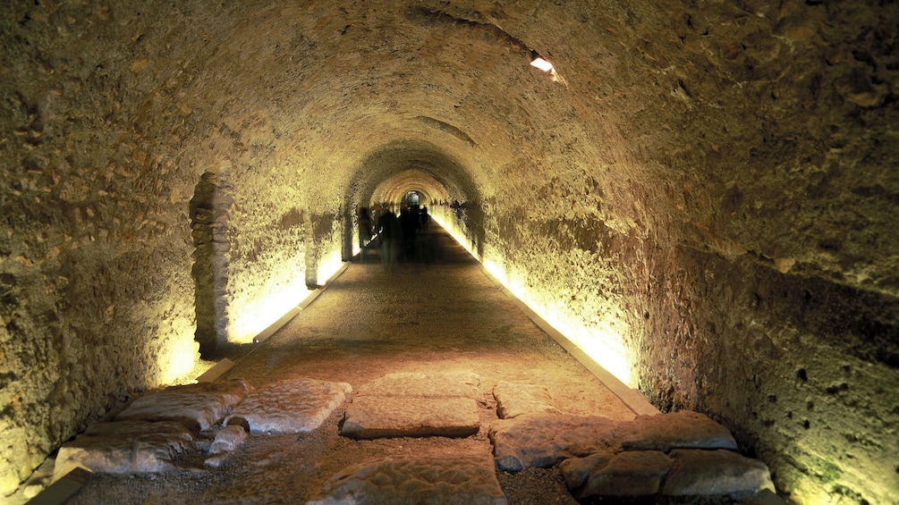 people walking down tunnel beneath Tarragona Cathedral church in Barcelona