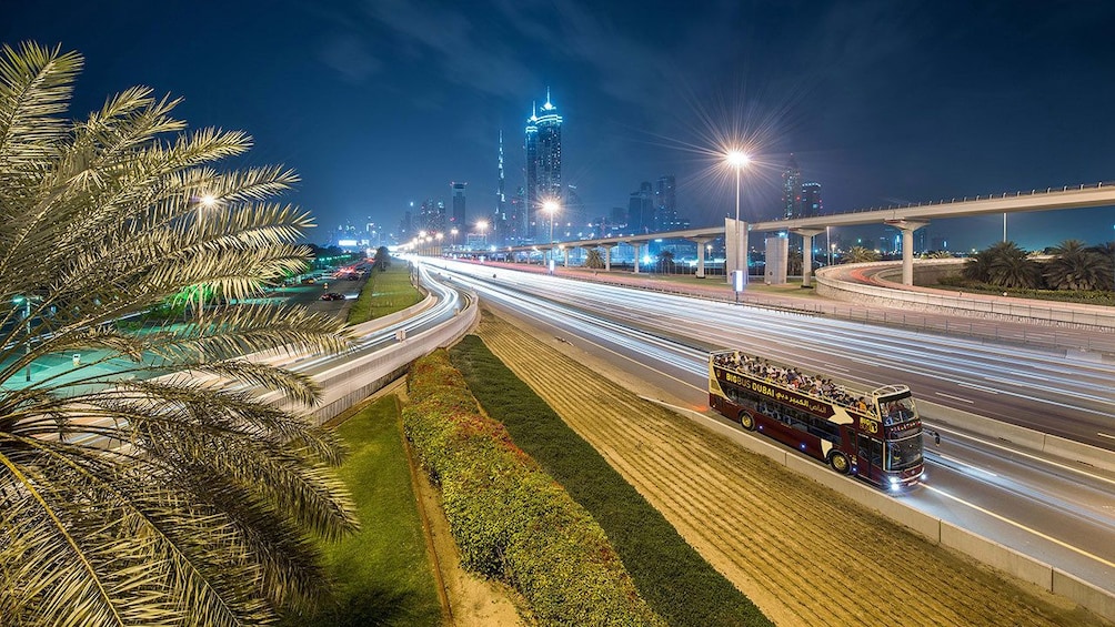 tour bus driving down empty street at night in Dubai