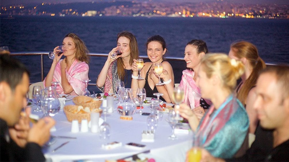 Guests smiling and enjoying drinks on the Bosphorus Dinner Cruise in Turkey