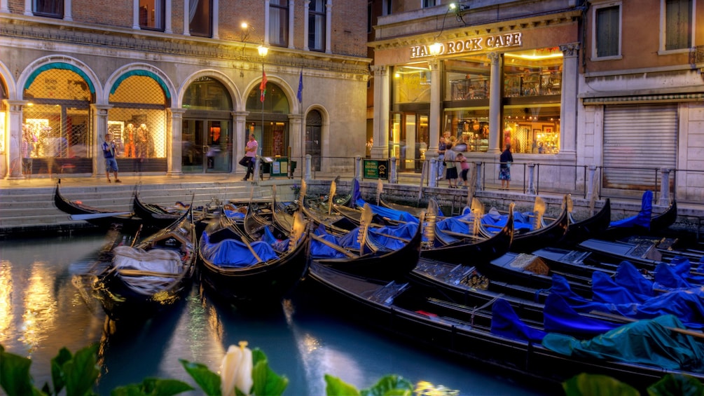 Gondolas parked in the water next to the Hard Rock Cafe in Venice Italy 