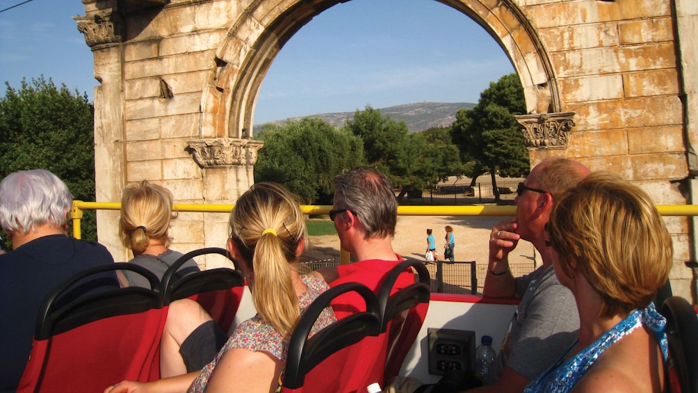 Open-top tour bus at the Arch of Hadrian in Athens