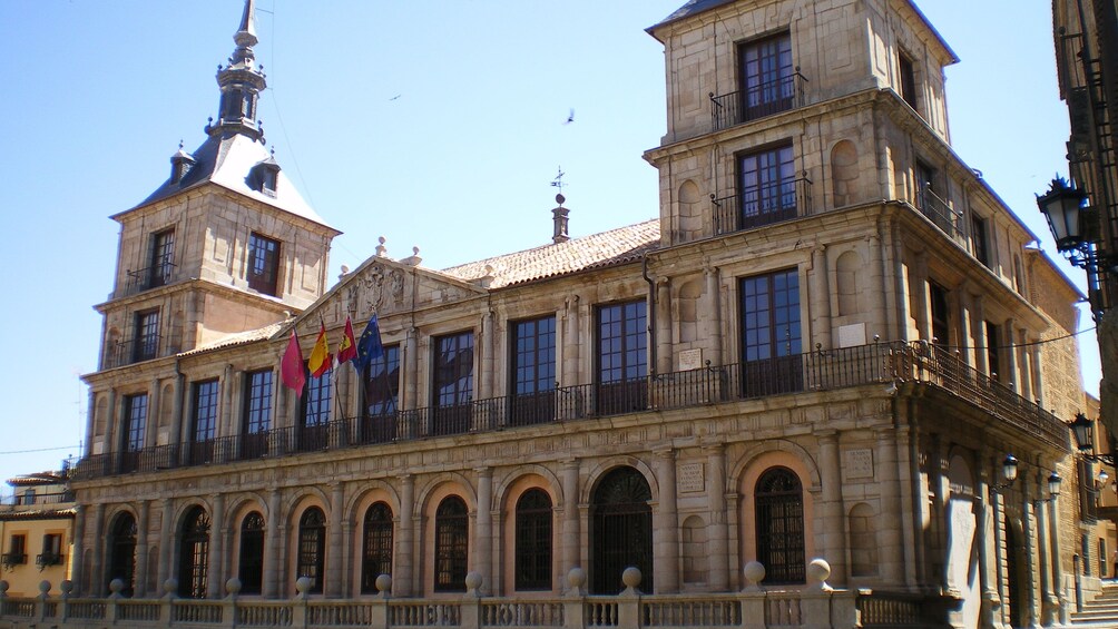 Building in Toledo with four flags hung in front of the building
