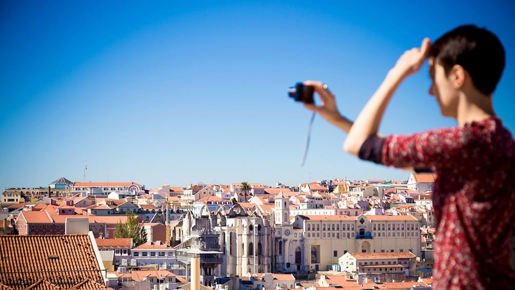 Tourist photographing the Alfama skyline in Lisbon, Portugal