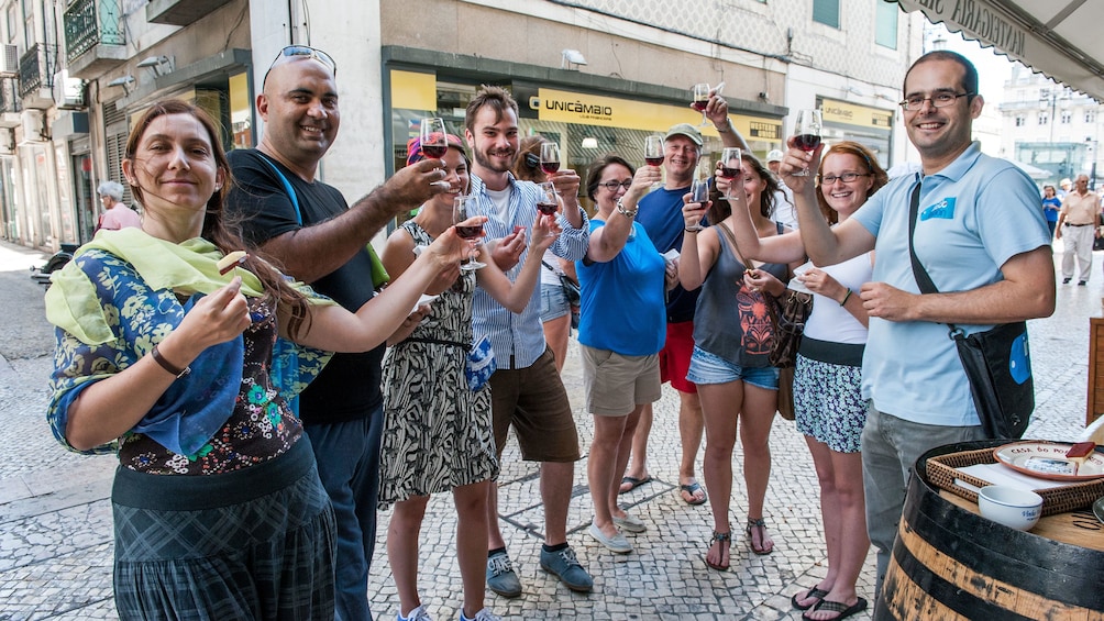 Tourists celebrate with a wine toast in the streets of Lisbon