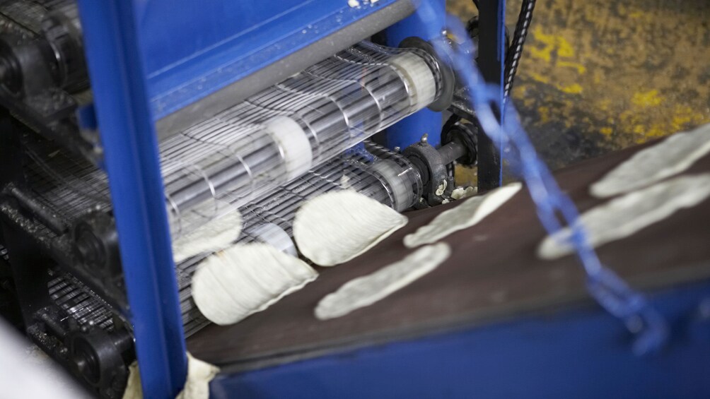 Uncooked dough entering a conveyer belt in the Tijuana up and down city tour in San Diego 