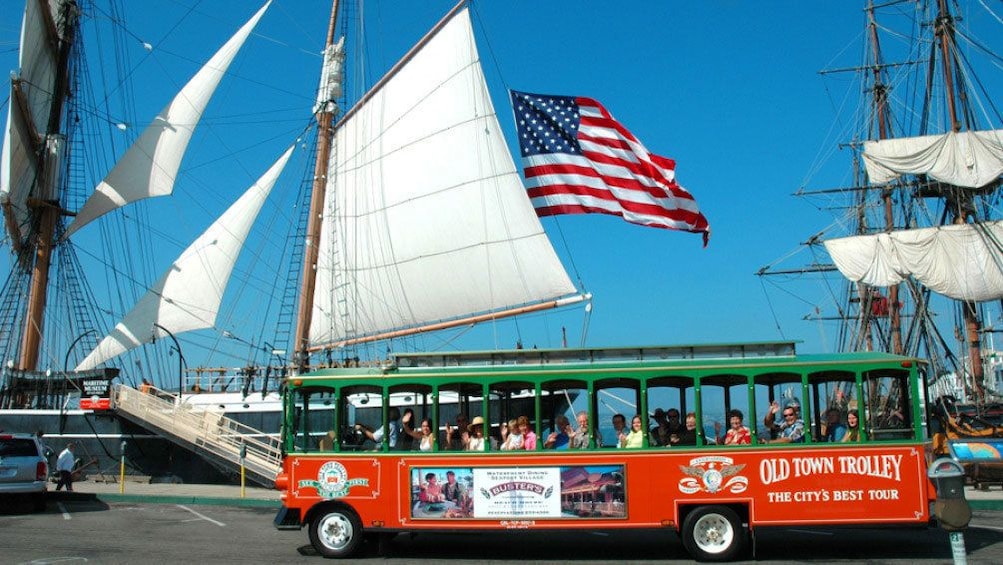 Hop on Hop off trolley near dock with sail boats in San Diego 