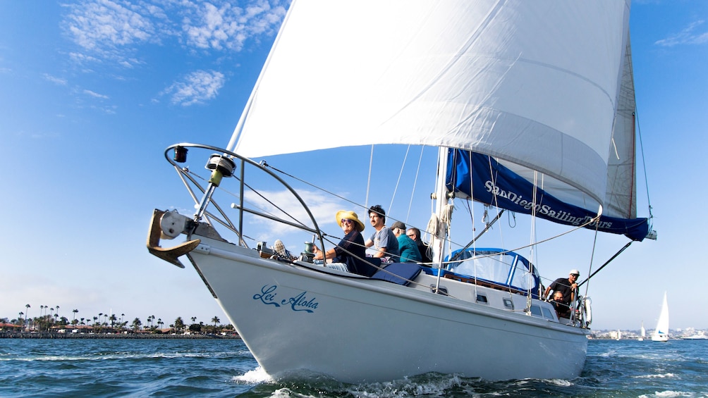 People enjoying the sun and breeze on deck of sailboat in San Diego