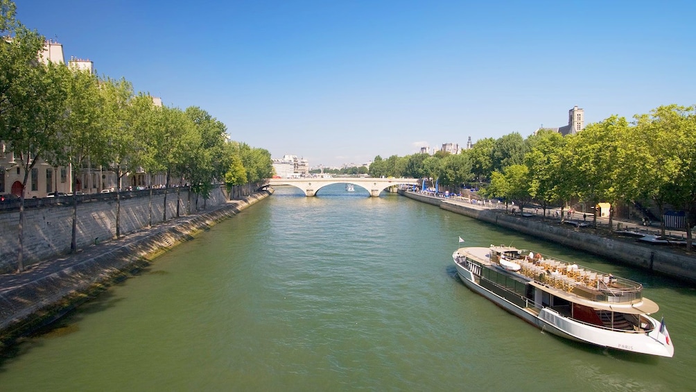 river ferry carrying passengers down channel in Paris