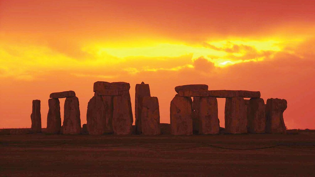 bright orange sunset behind Stonehenge in London