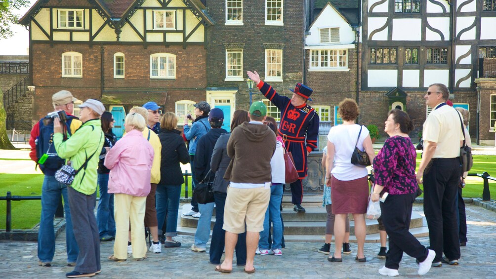 beefeater tour guide directs visitors attention to the left at Tower of London