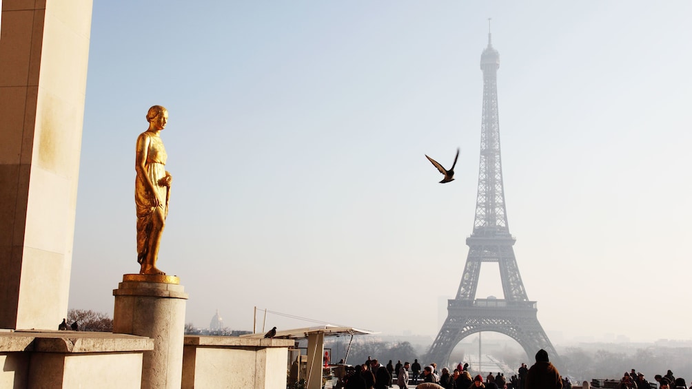 Golden statue faces Eiffel Tower in Paris