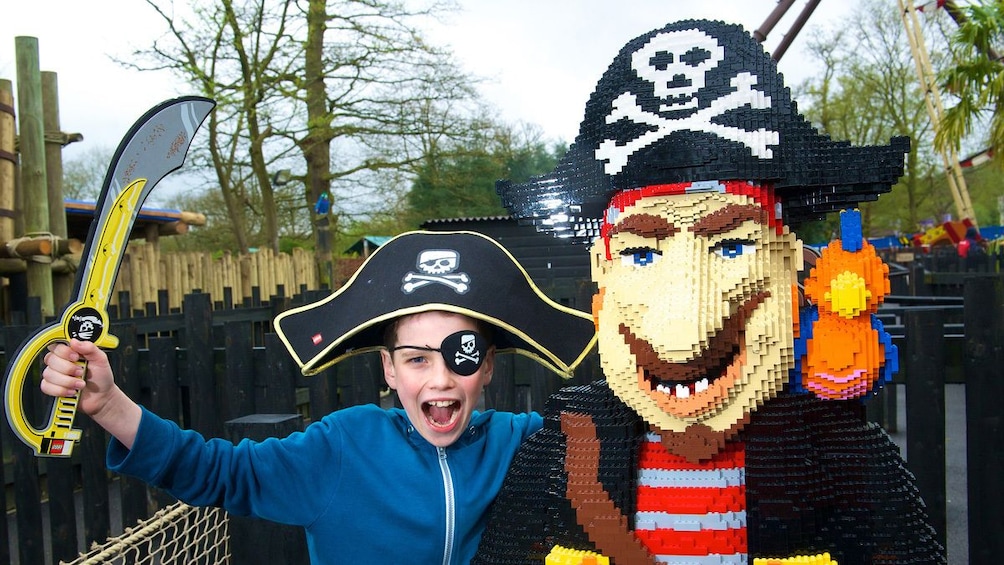young boy poses next to Lego Pirate at Lego Land in London