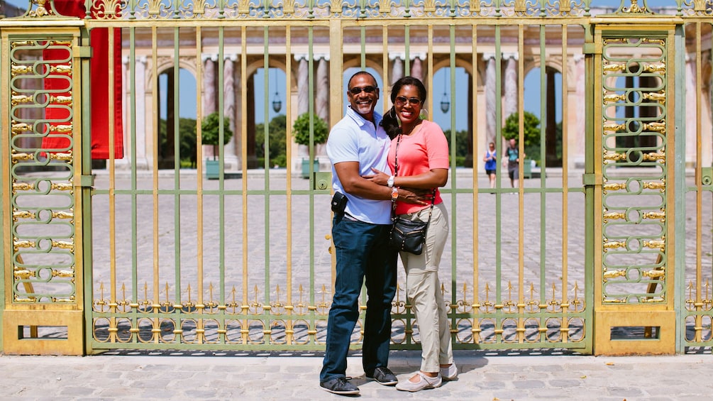 Couple infront of the gates of Versailles.