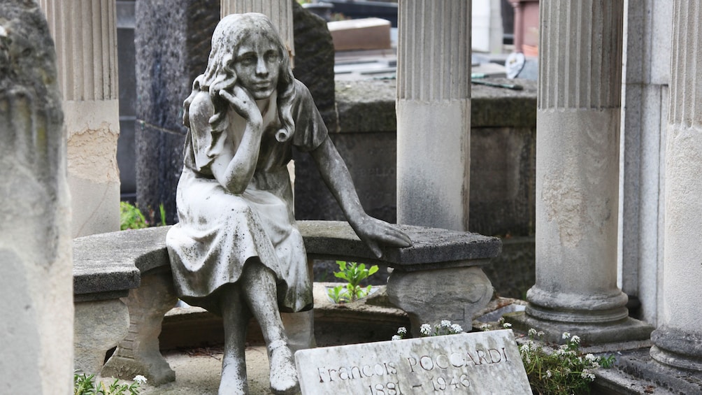 Statue of a young girl on a grave in Paris.