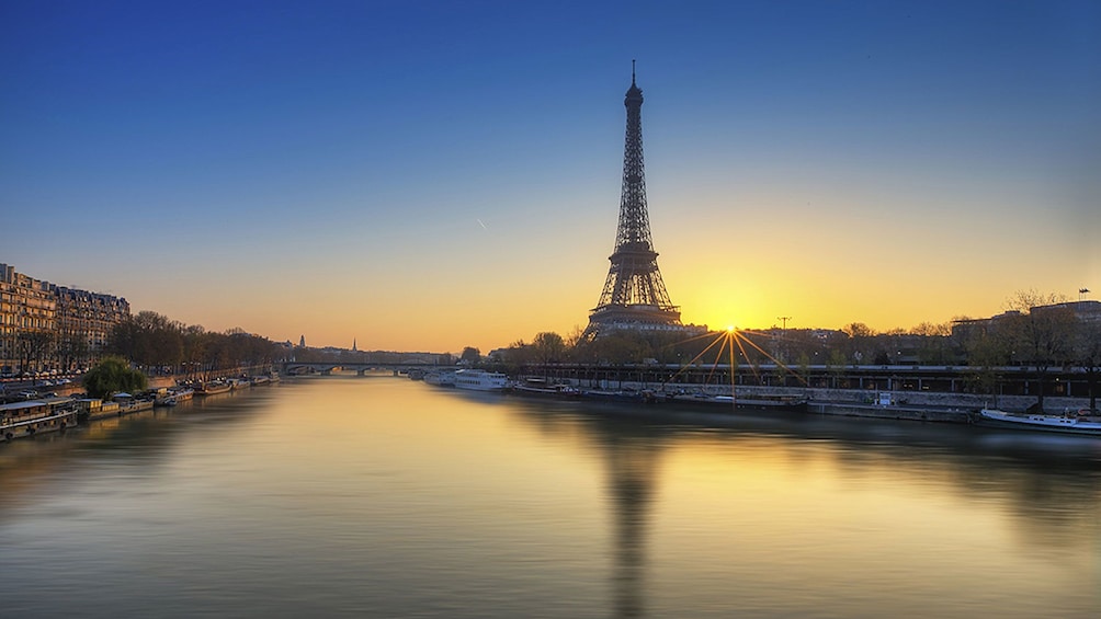 The Eiffel Tower overlooking the Seine river at sunset in Paris.