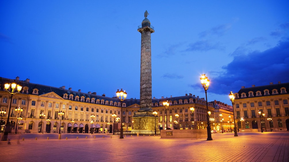 Streetlamp lit square in Paris at night.