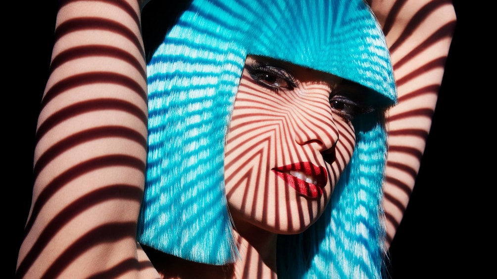 Cabaret performer in striped lighting during show  at the Crazy Horse in Paris