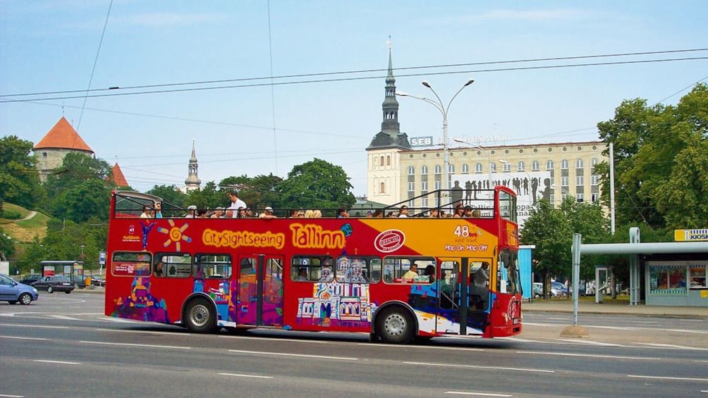 A hop on hop off bus driving past churches in Tallinn