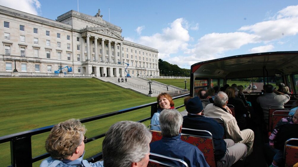 People on the top level of a double decker bus in Belfast