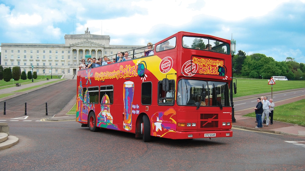 Hop on Hop off bus driving past the Northern Ireland Assembly building in Belfast