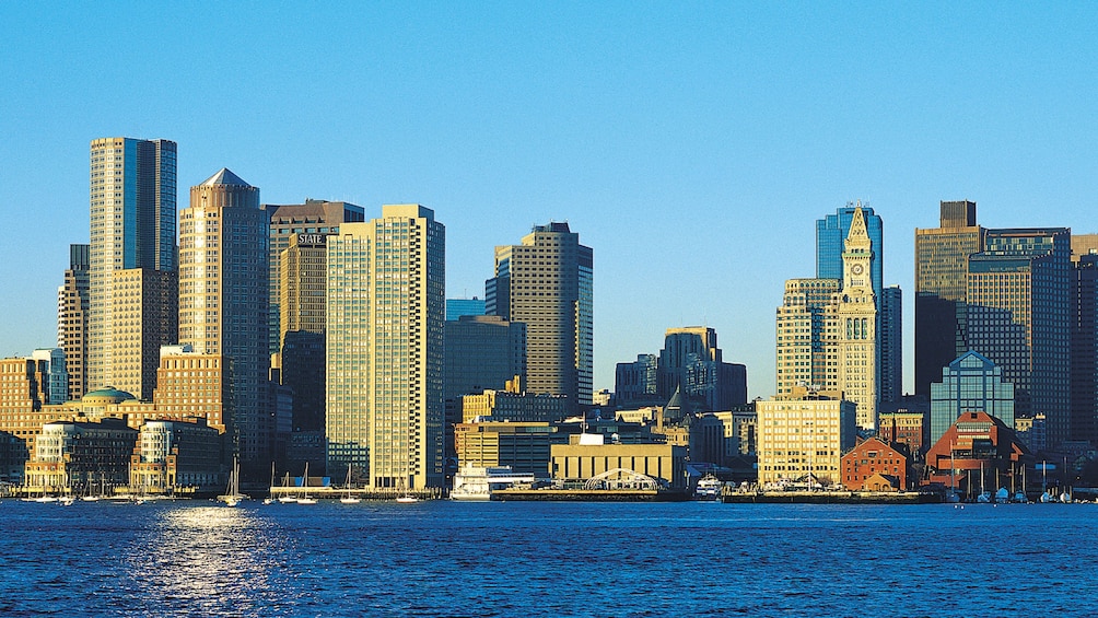 Sunlight hitting the tall buildings that line the coast of Boston Harbor