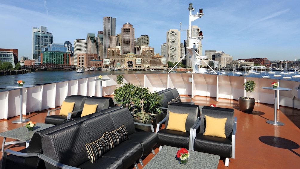 Deck lounge area onboard the dinner cruise ship with the Boston skyline in the background