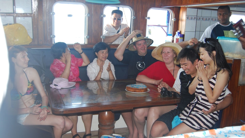 visitors celebrating with cake on the boat in Fiji