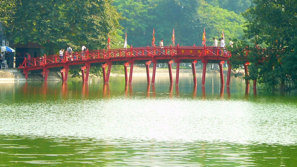crossing a red bridge above the water in Vietnam