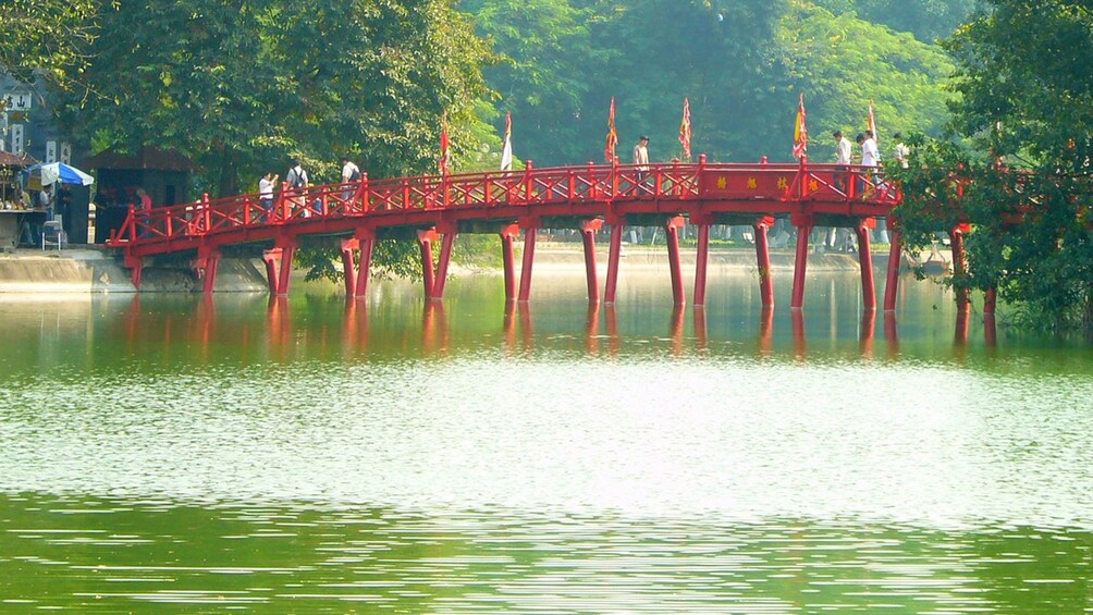 crossing a red bridge above the water in Vietnam