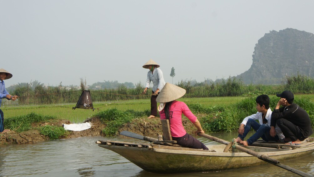 woman rowing passengers on a boat in Vietnam