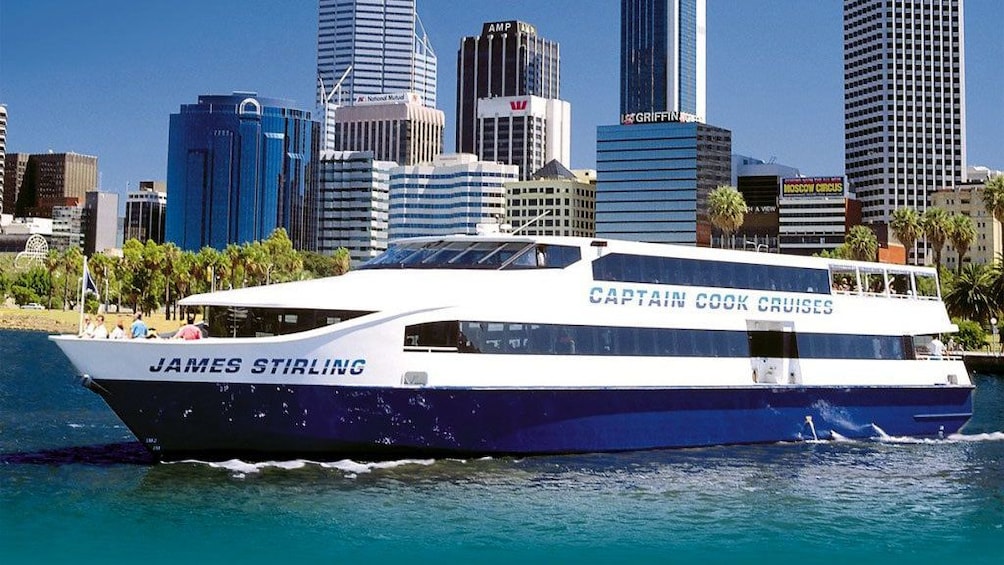 a cruise ship sailing past a city on the swan river