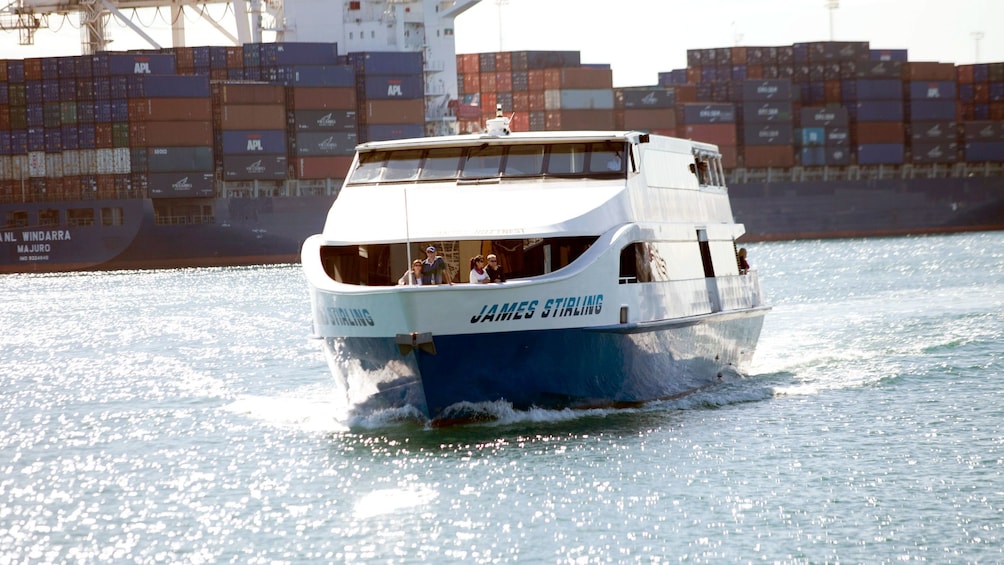 cruise ship sailing past a shipping container carrier  on the swan river