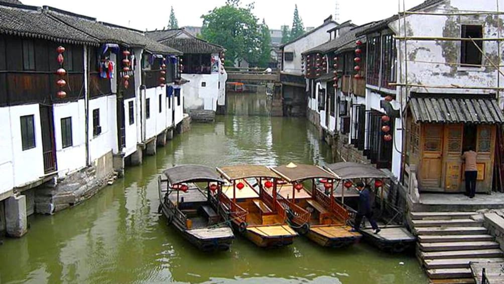 Four water boats parked along the water at the Zhujiajiao Water Village in Shanghai 