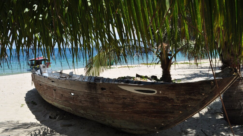 Boat in the shade on the sandy beaches at Cu Lao Cham Marine Park in Vietnam