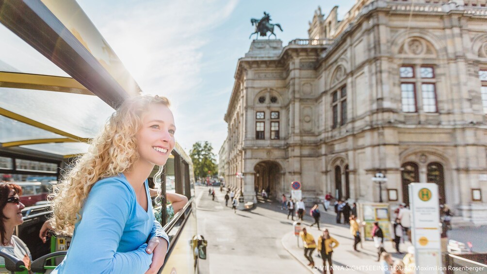 Woman leaning out of open window on Hop-On Hop-Off bus in Vienna