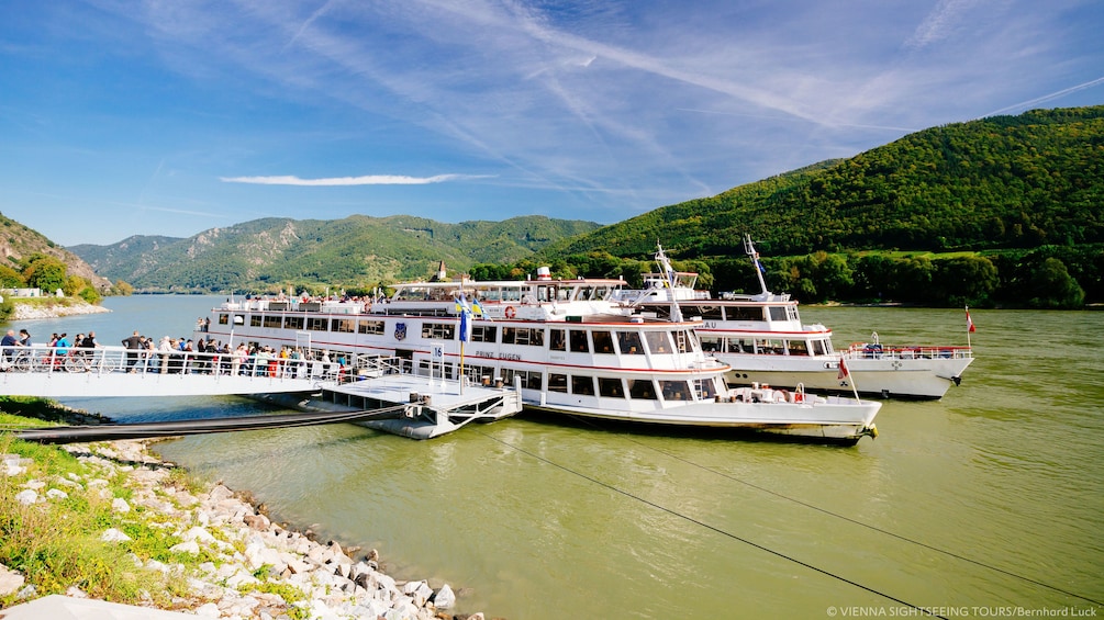 Tour boats moored to pier on river in Wachau