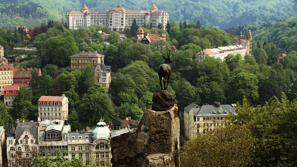 Leaping deer statue at a lookout with a view of the city in the distance in Karlovy Vary