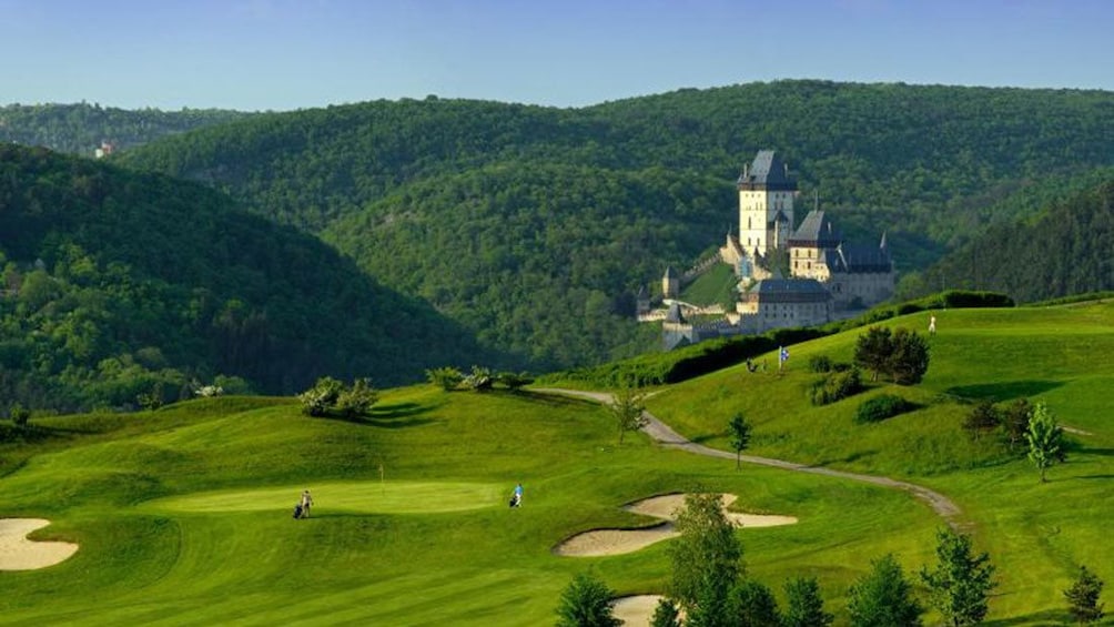 Sprawling green golf course with Karlstejn Castle in the distance in the Czech Republic