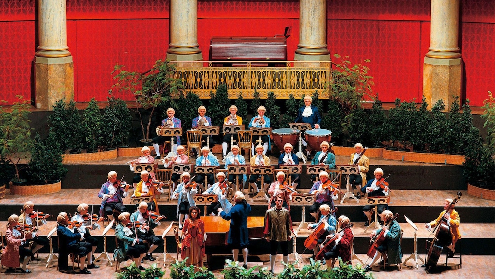 Conductor and orchestra in costumes and wigs during a performance in Vienna