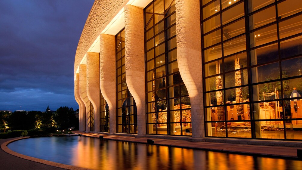 Show item 3 of 10. Reflecting Pool lit up at night outside the Grand Hall of the Canadian Museum of Civilization in Ottawa