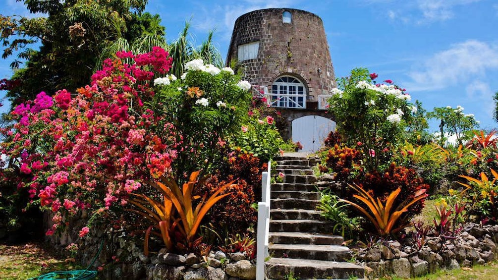 Colorful flowers blooming around a historical brick building on Nevis Island