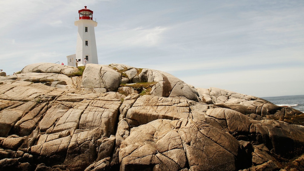 Beautiful view of the lighthouse and the shore's massive boulders at Peggy's Cove