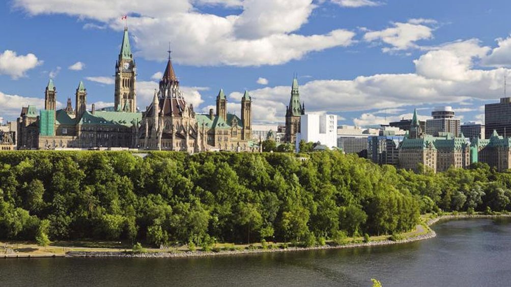 Green towers of Parliament Hill near the river in Ottawa