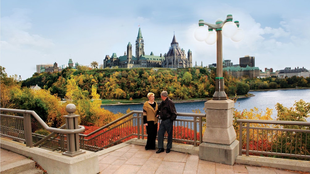 Couple standing a view point with the river and Parliament Hill in the background in Ottawa