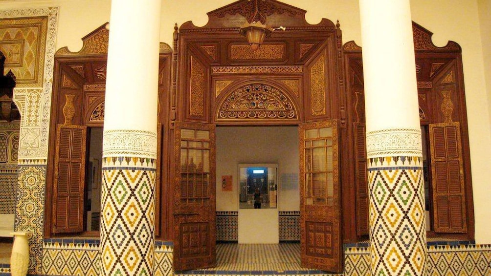 Mosaic pillars and large wooden doorway at the Marrakech Museum