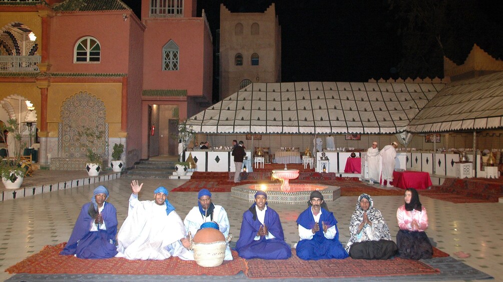 Seated performers in colorful robes during a performance in Marrakech